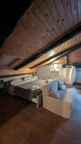 a large bedroom with a bed and a couch at Mansarda 2 in Commezzadura