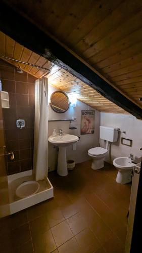 a bathroom with two sinks and two toilets at Mansarda 2 in Commezzadura
