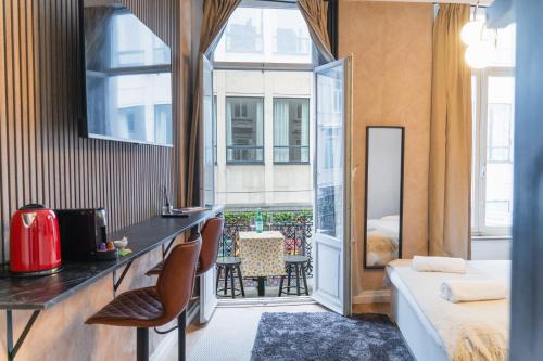 een hotelkamer met een balkon met een bed en stoelen bij 3 Stylish Studios at a Great Location in Gent in Gent