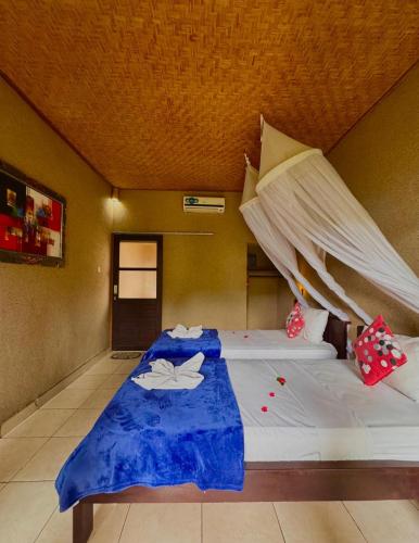 a bedroom with a bed with a mosquito net at Sudi Guest House in Pemuteran