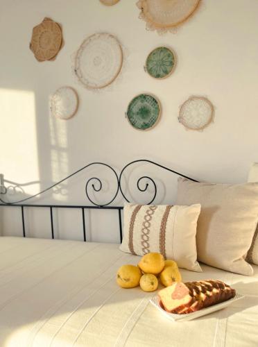 a plate of food on a bed with plates on the wall at Katastega Tinos in Istérnia