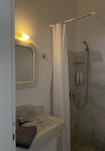 a bathroom with a shower and a sink at Katastega Tinos in Istérnia