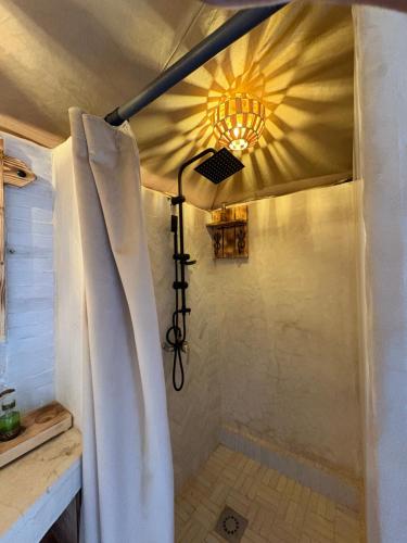 a bathroom with a shower with a shower curtain at Peaceful Luxury Camp in Merzouga