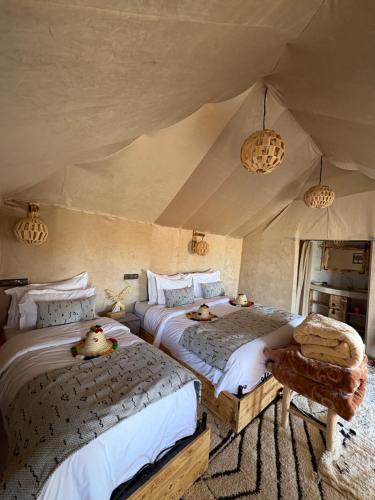 a bedroom with two beds with ducks on them at Peaceful Luxury Camp in Merzouga
