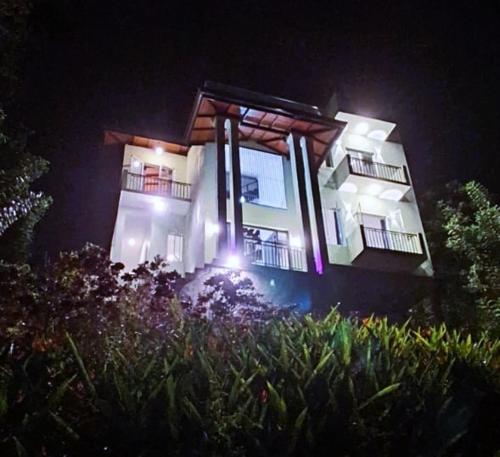 een groot gebouw met 's nachts verlichting bij mountain retreat villa in Kandy