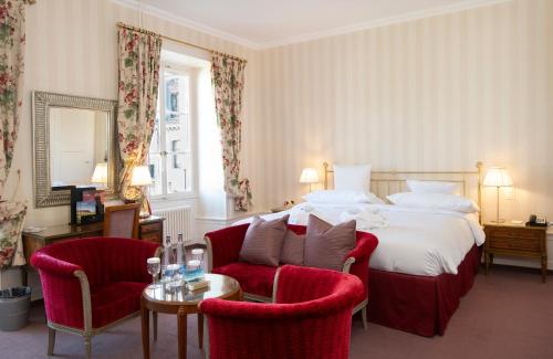 a hotel room with a bed and two chairs at La Résidence des Trois Couronnes in Vevey