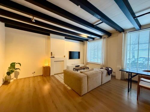 a living room with a couch and a table at Perfectly located home between Den Bosch & Vught in Vught