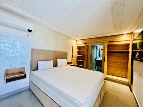 a bedroom with a large white bed in a room at Lovely studio 4th floor No Elevator in El Gouassem
