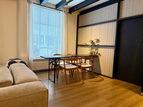 a living room with a table and a couch at Perfectly located home between Den Bosch & Vught in Vught