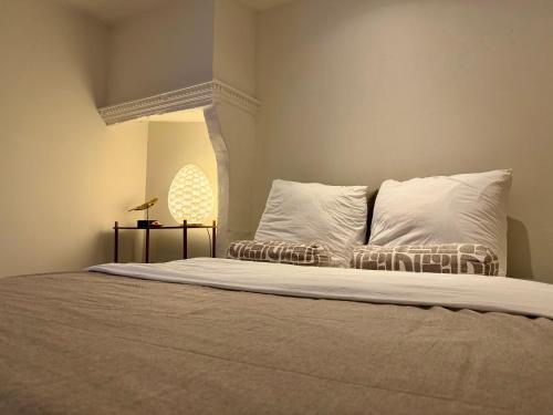 a bed with white sheets and pillows in a room at Perfectly located home between Den Bosch & Vught in Vught