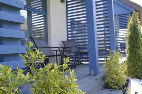 a deck with chairs and tables on a house at Déjà Blue - ADULT ONLY in Sfântu Gheorghe
