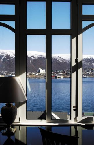 a window with a view of the water and mountains at Radisson Blu Hotel Tromsø in Tromsø
