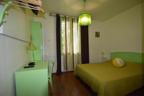 トゥーロンにあるVilla le 180 cinqのベッドルーム1室(緑のベッド1台、ランプ付きテーブル付)