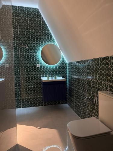 a bathroom with a shower and a toilet and a mirror at SkyHouse Shahdag in Əniq