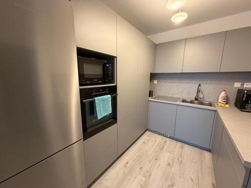 a kitchen with a stainless steel refrigerator and a sink at Oáza Living Mohelnice in Mohelnice