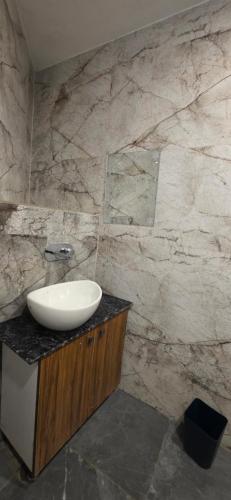 a bathroom with a sink and a marble wall at Devlok Homes in Rishīkesh