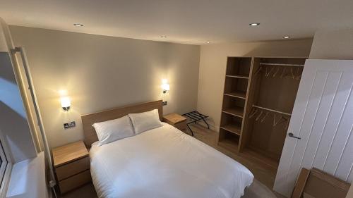 a bedroom with a white bed and a closet at Santíago Retreat in Wenvoe