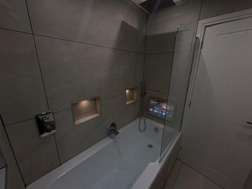 a bathroom with a tub and a shower with lights at Santíago Retreat in Wenvoe