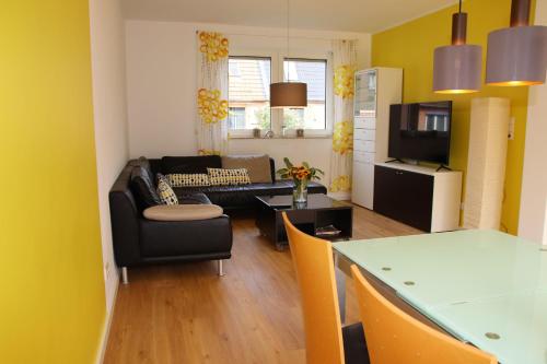 a living room with a couch and a table at Urlaubswerft-Dock-13-|-Ihr-stilvolles-Erholungsparadies in Kiel