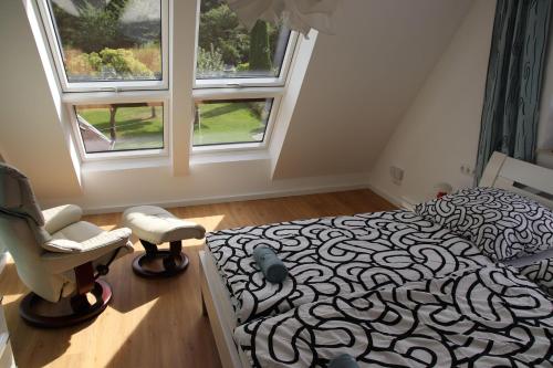 a bedroom with a bed and a chair and a window at Urlaubswerft-Dock-13-|-Ihr-stilvolles-Erholungsparadies in Kiel