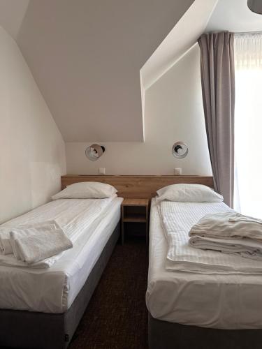 due letti singoli in una stanza con finestra di Twardowski Łeba a Łeba