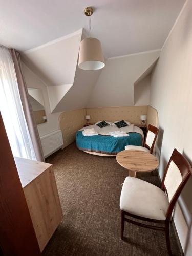 una piccola stanza con un letto e un tavolo di Twardowski Łeba a Łeba