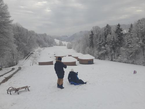 een paar mensen die in de sneeuw staan bij Glamping Bionic healing village in Slovenska Bistrica