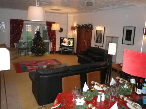 a living room with a couch and a christmas tree at Bridge Hall Apartments in Weston-super-Mare