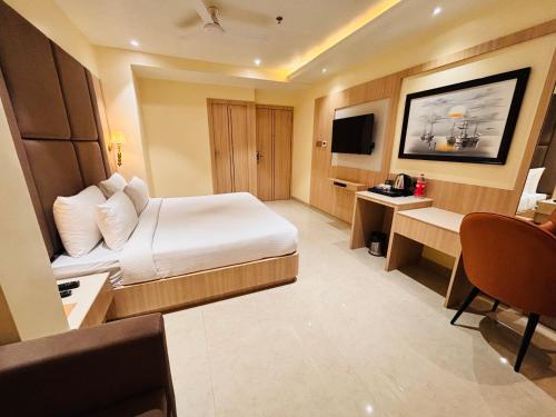 a hotel room with a bed and a desk at Hotel The Elite in Jabalpur