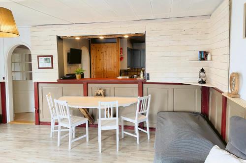 una cucina con un tavolo e sedie in una stanza di Gemütliche Ferienwohnung in Nordschweden a Glommersträsk