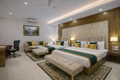 a hotel room with two beds and a desk at Hotel The Prithvi Near Delhi Airport in New Delhi