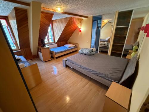 een slaapkamer met een bed in een kamer met houten vloeren bij Résidence Les Cascades in Le Mont-Dore