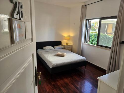 a small bedroom with a bed and a window at Blife Sunya private rooms near airport and nature in Faro