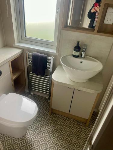 a bathroom with a white sink and a toilet at Rockley Park, Poole, Stunning Sea View, Close to Beach in Poole
