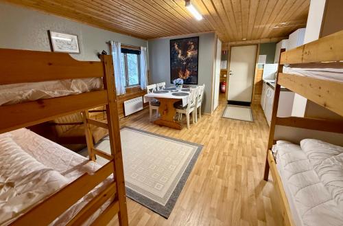 een kamer met een stapelbed, een tafel en een eetkamer bij Kolbackens Camping & Stugby in Åsarna