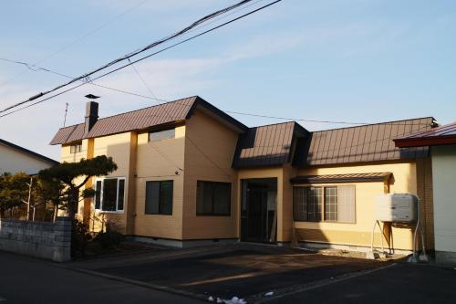 a house with a metal roof on a street at Shoe Cream Inn Higashikawa in Higashikawa