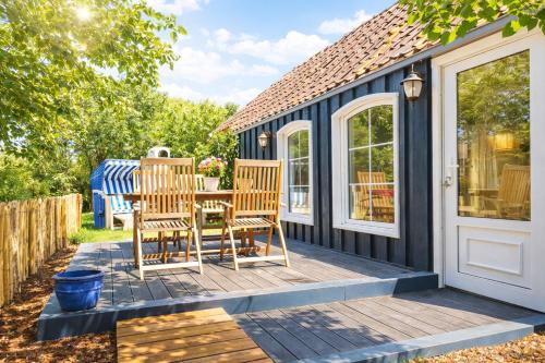 een terras met twee stoelen en een tafel op een huis bij Huus an`t Dörpsdiek in Krummhörn