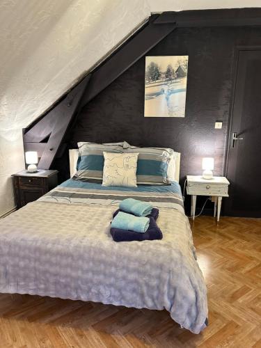 a bedroom with a large bed with blue pillows at La maison Bellevue in Antignac