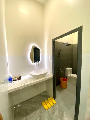 a bathroom with a sink and a mirror at Gạo homestay Dốc lết in My Luong