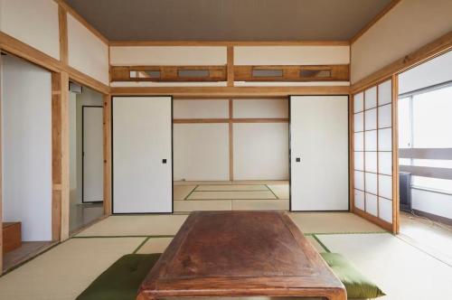 a room with a wooden table in the middle of it at Yamatsu Tokyo House in Tokyo