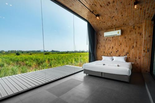 a bedroom with a bed and a view of a field at The Brick Huahin Pool Villa in Hua Hin