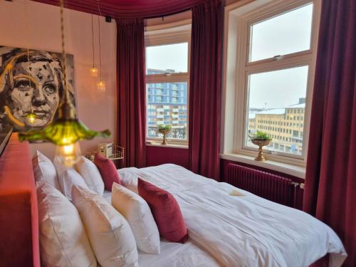 una camera da letto con un grande letto bianco con cuscini rossi di Hotell Onyxen, boutique- & lifestyle, Adults Only a Göteborg
