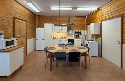een keuken met een tafel en een aantal witte apparaten bij Kolbackens Camping & Stugby in Åsarna