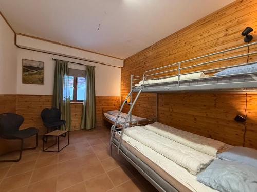 a bedroom with two bunk beds and a desk at Kolbackens Camping & Stugby in Åsarne