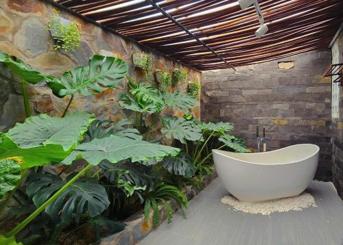 un bagno con vasca accanto alle piante di For You Ninh Binh Boutique a Ninh Binh