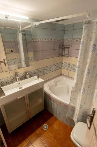 a bathroom with a tub and a sink and a toilet at Elena's Apartment in Therma Samothrace in Therma