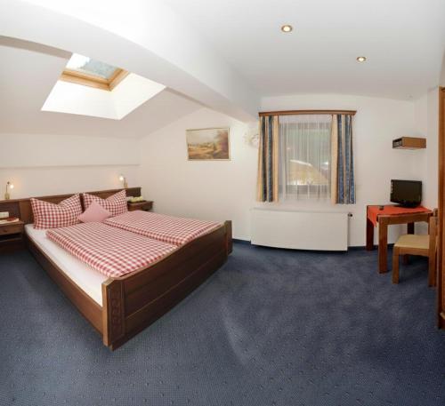 a bedroom with a bed and a desk and a window at Appartment Valnova / Barga in Partenen