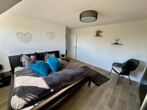 Ein Schlafzimmer mit einem Bett mit blauen Kissen und Herzen an der Wand in der Unterkunft Eifelpause Vulkan in Bleckhausen