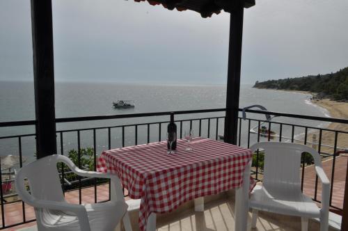 a table and chairs on a balcony overlooking the water at Giannis Maria Apartments in Psakoudia