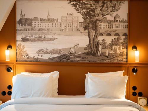 a bedroom with a painting above a bed with white pillows at Mercure Paris Bastille Marais in Paris
